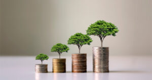 Image representing financial growth. Coins laid out in increasing amounts on a table.