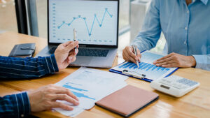 Business people discussing the charts and graphs showing the results of their successful teamwork.