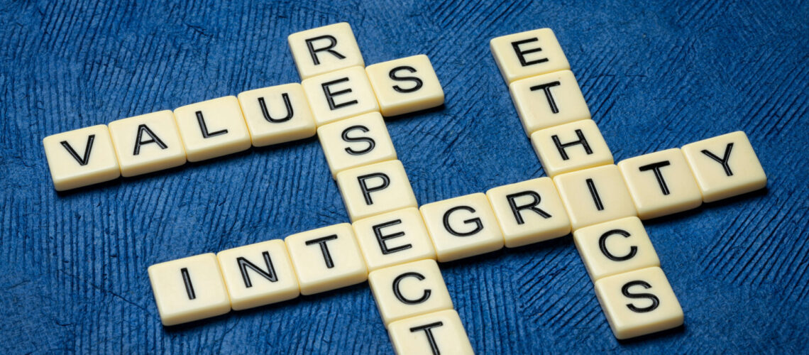 integrity, respect, values and ethics crossword in ivory letters against textured handmade blue paper, moral obligations, conduct and personal devleopment concept