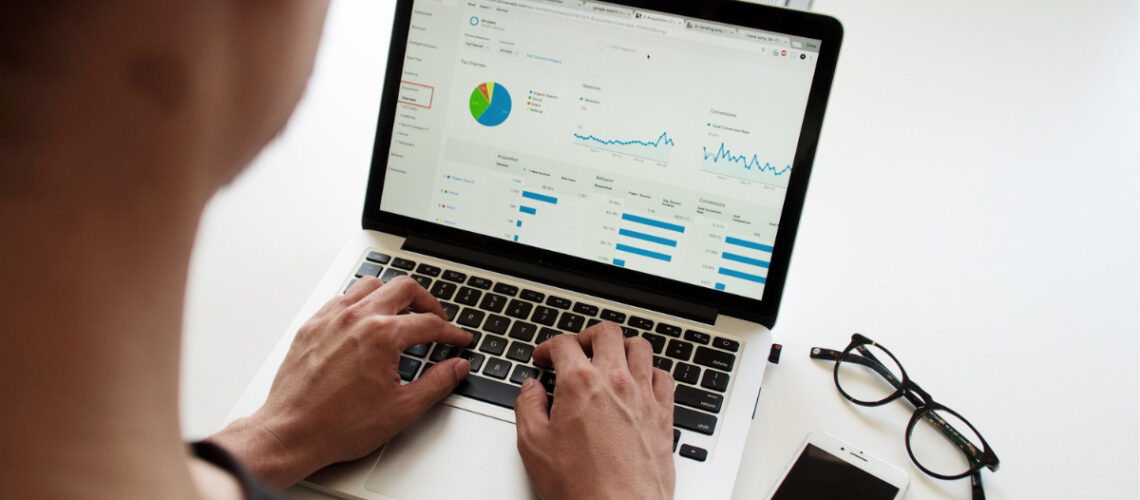 man on a laptop looking at statistics and data charts