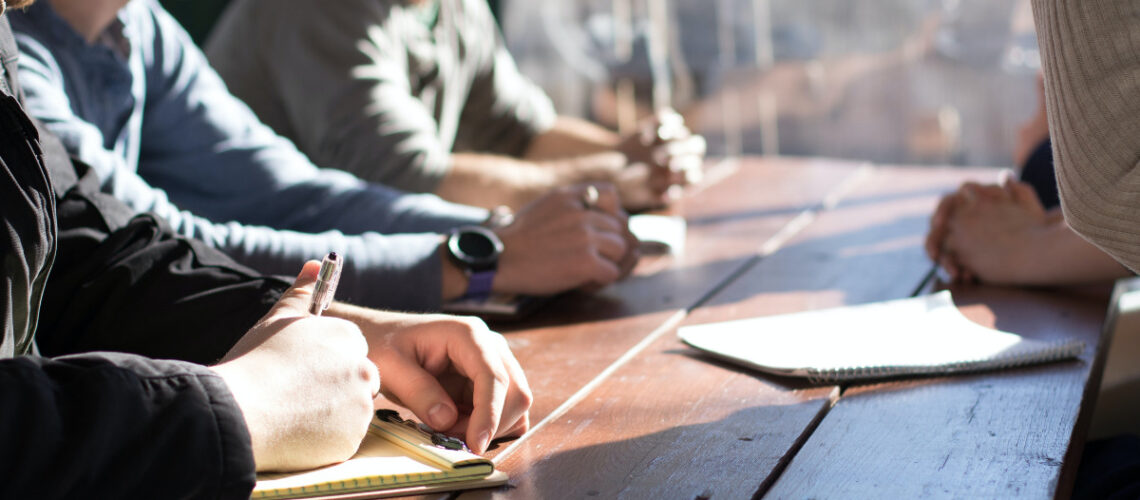 business professionals sitting around a desk having a meeting