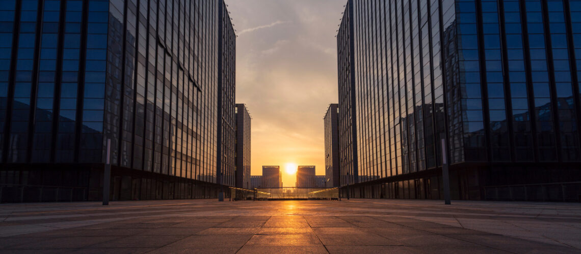 Two office buildings parallel to each other at sunset.