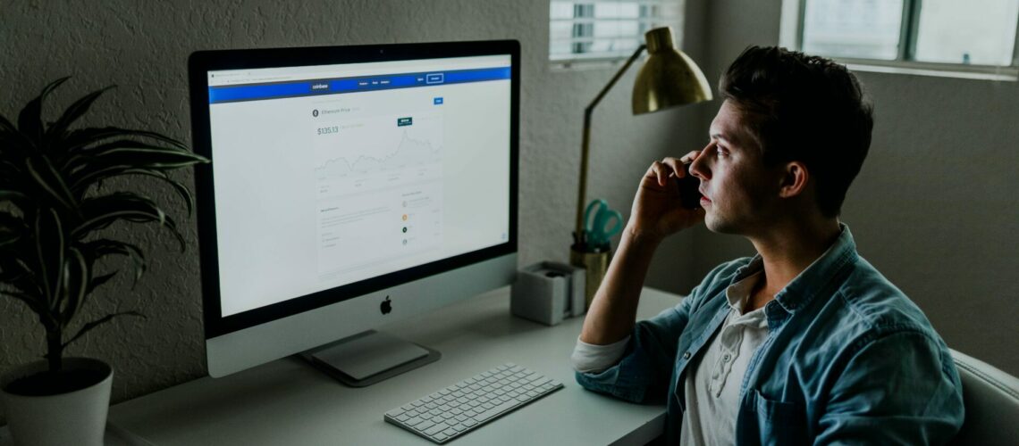 Man talking on the phone in front of computer