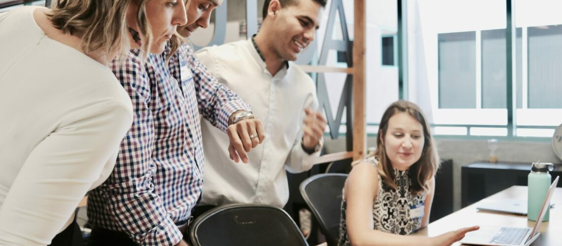 people discussing around a computer